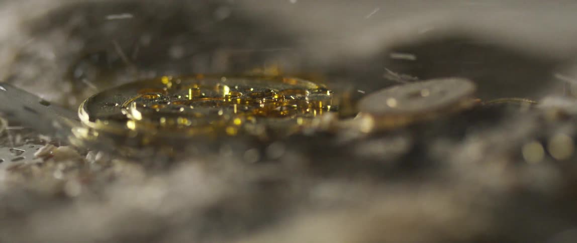 Golden broken watch in the sand blowed by the wind