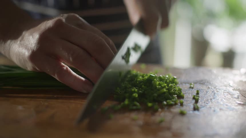 A man chopping onions at home