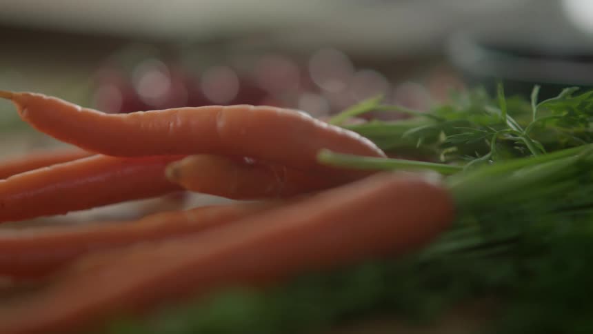 Carrot bunch with fronds attached laying on a counter