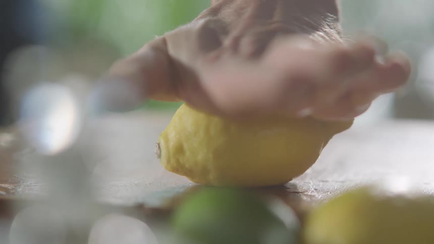 A man rolls a lemon under his hand
