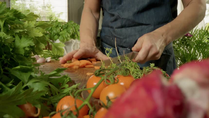 Man chopping vegetables on wooden countertop