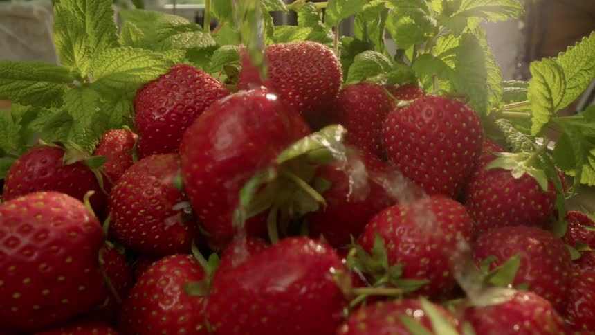 Water is being poured on strawberries