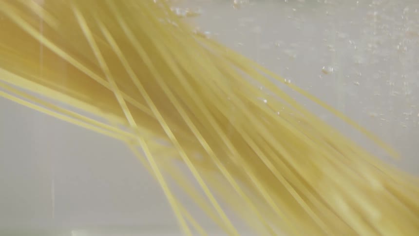 Spaghetti being submerged in water
