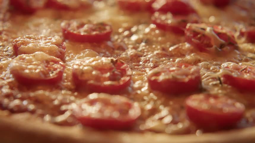 Close up of a recently cooked tomato and cheese pizza still bubbling hot