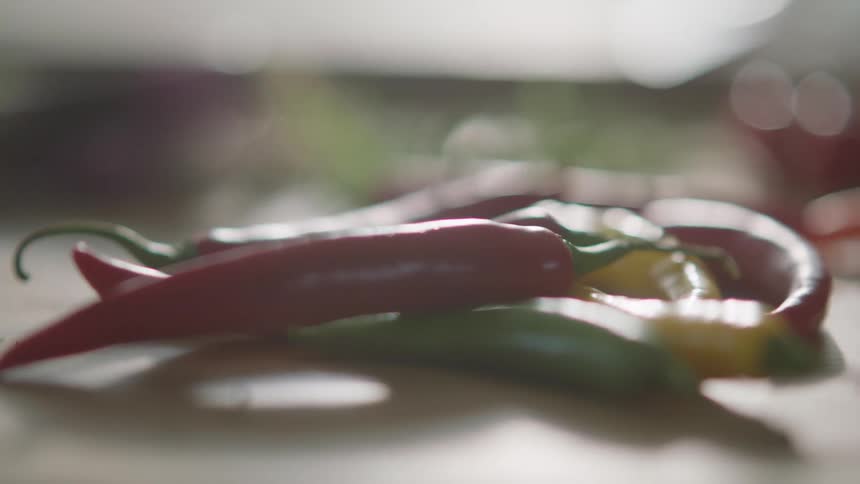 Several different colors of peppers sit on a counter top