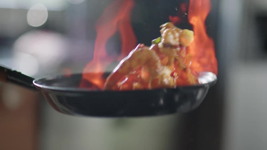 Shrimp and various seafood cooking in a pan on a kitchen