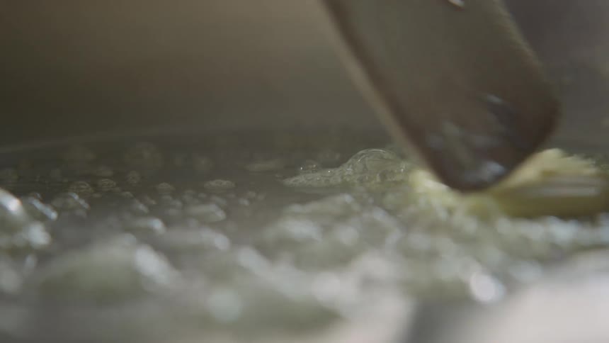 Close up of butter melting in a hot pan