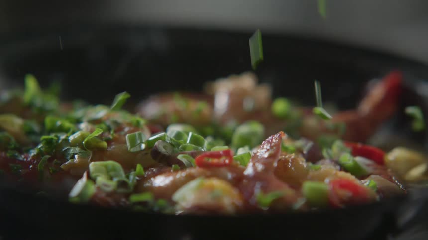 Green onions are spread onto meal in skillet
