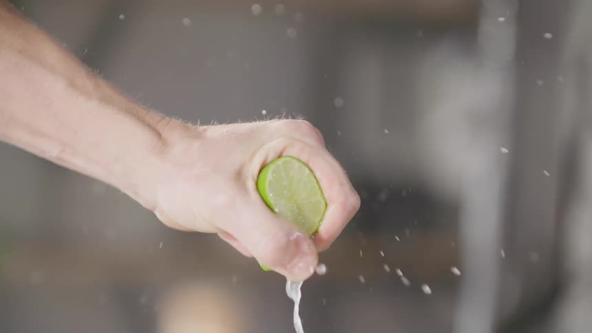 A white man squeezes the juice out of a lime