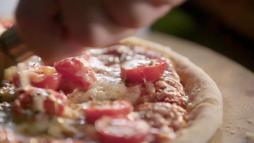 A person cutting a pizza