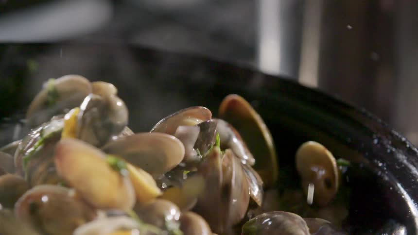 Seafood being tossed in a pan and cooked