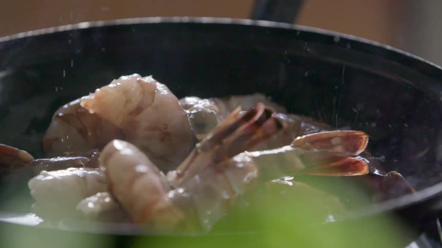Shrimp are frying in a hot pan