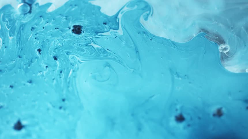 Blue fluid poured into a different type of liquid