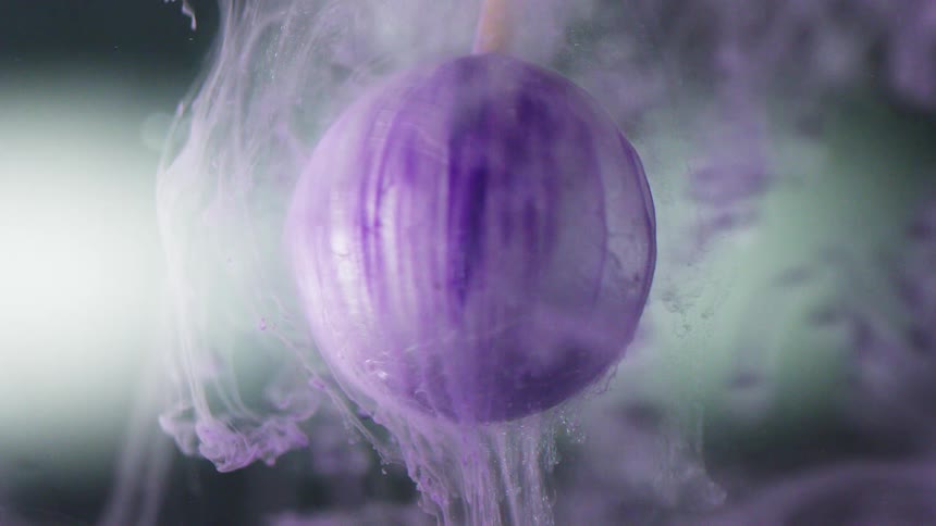 Purple dye coming off a sphere in liquid