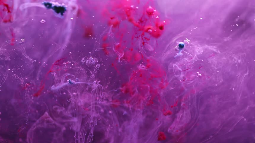 Colored dye drops into the liquid and spreads