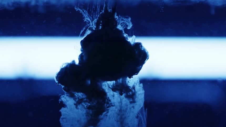 Blue liquid is poured on a blue sphere inside a vat of water