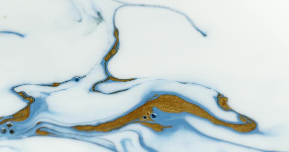 Blue and gold paint swirling in white paint