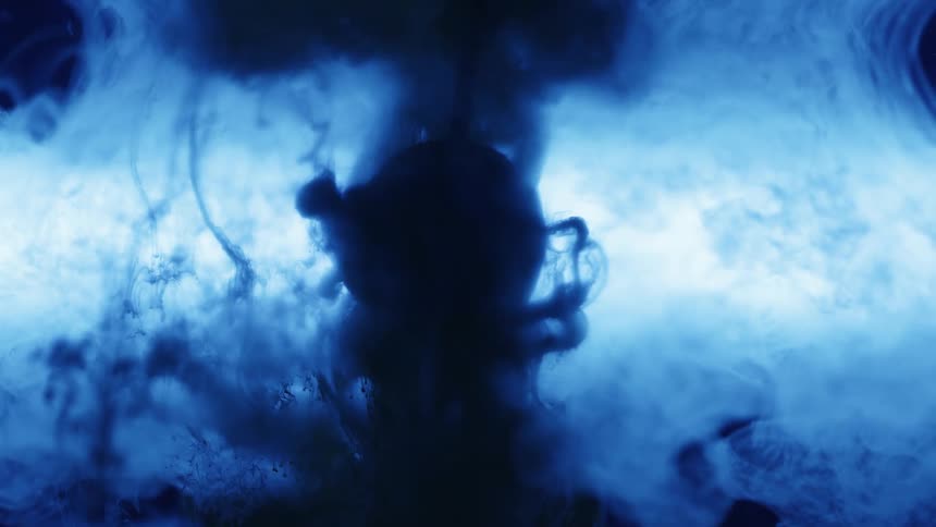 Blue ink flowing down a ball suspended on a tank of water