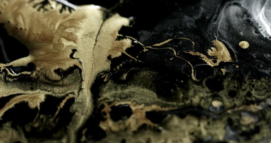 Gold and black paints create a swirled pattern when combined