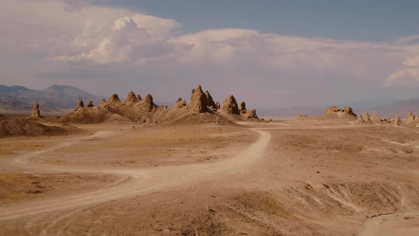 Dirt trails wind through a desert and sand dunes