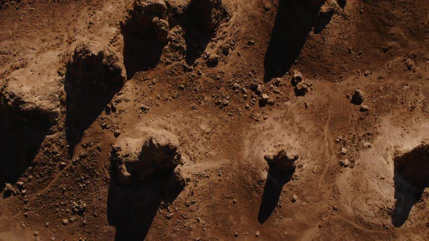 Aerial top down view of rock formations on the desert at sunset