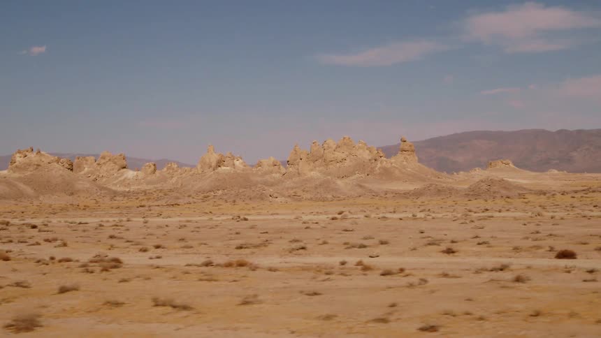 Dirt roads run in different directions in a vast desert near a canyon