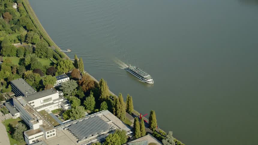 A cruise ship sails off the coast where a building sits