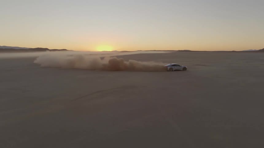 A car races in the desert giving off dust clouds