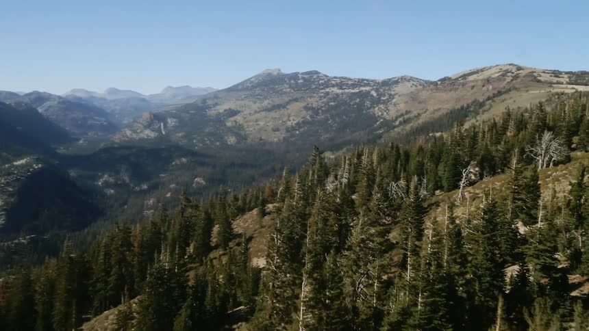 The top of the mountains are lined with trees