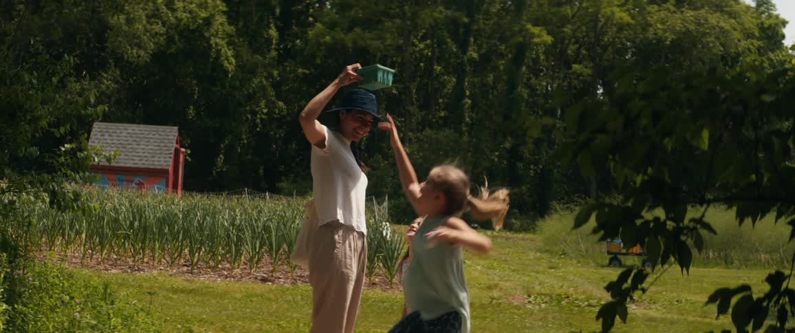 A woman plays with her children in the yard