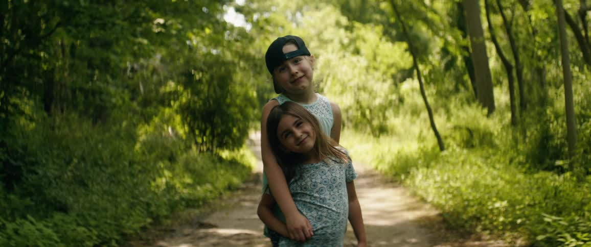 Siblings posing for a picture on a woodsy hiking trail