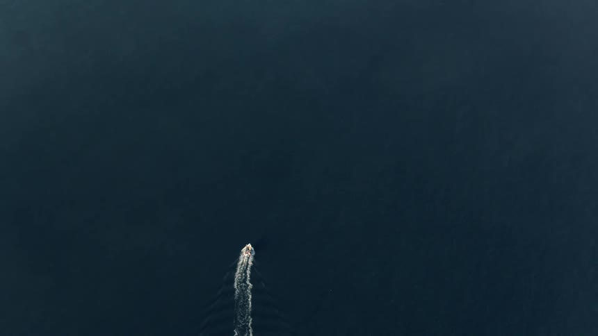 A boat leaves a white wake as it moves through the smooth water