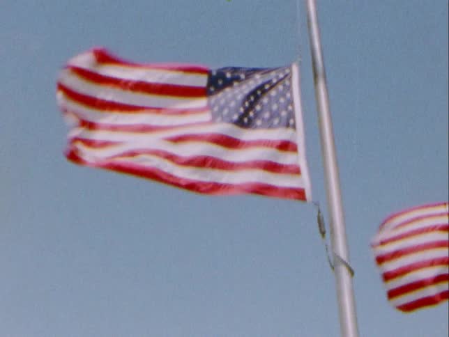 American flags flap in strong breeze against clear blue sky