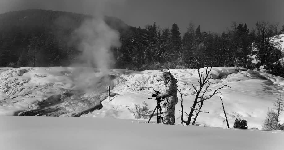 A man standing in the snow takes photos