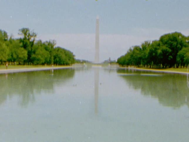 Lake sits in front of a monument near the trees