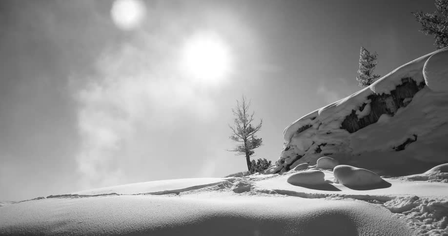 Steam emerging from the ground of a snowy landscape on a sunny day
