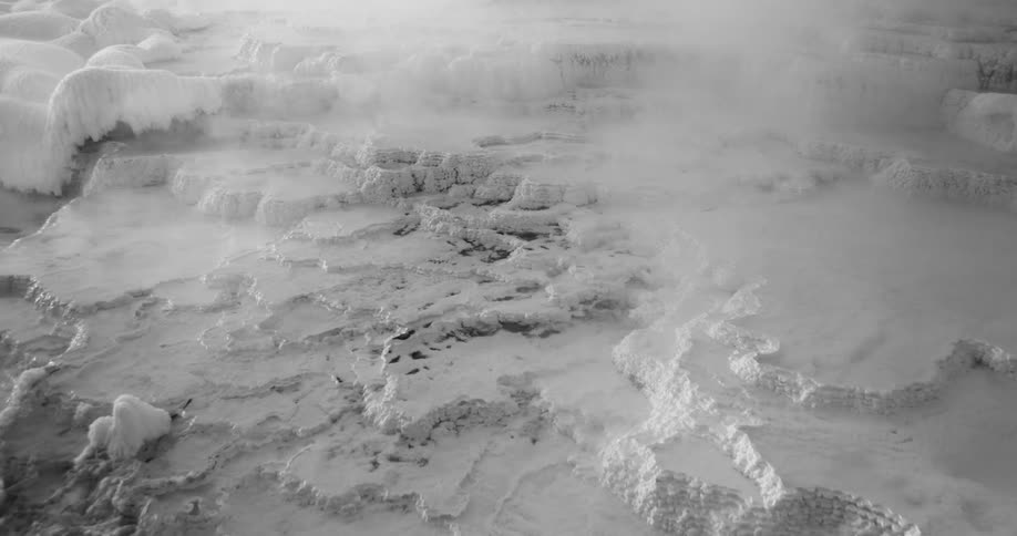 Mist drifts over a snowy landscape