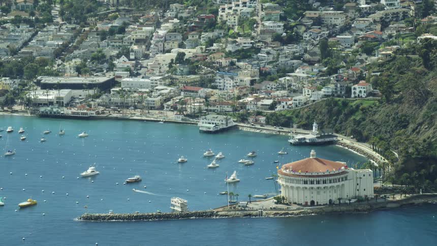 A large amount of boats sit along a coastal hillside town in the water