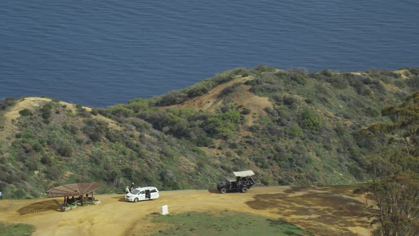People exiting vehicles near pavilion on a mountain