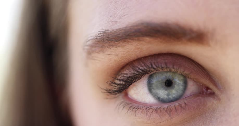 Close up of closed eyelid opening up to reveal blue eyes