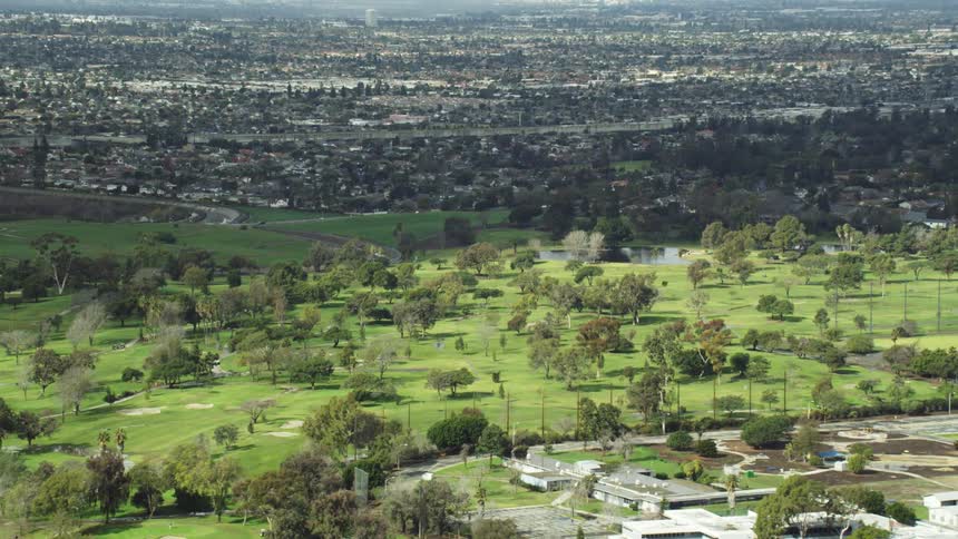 A large golf course spans the distance of an adjacent neighborhood