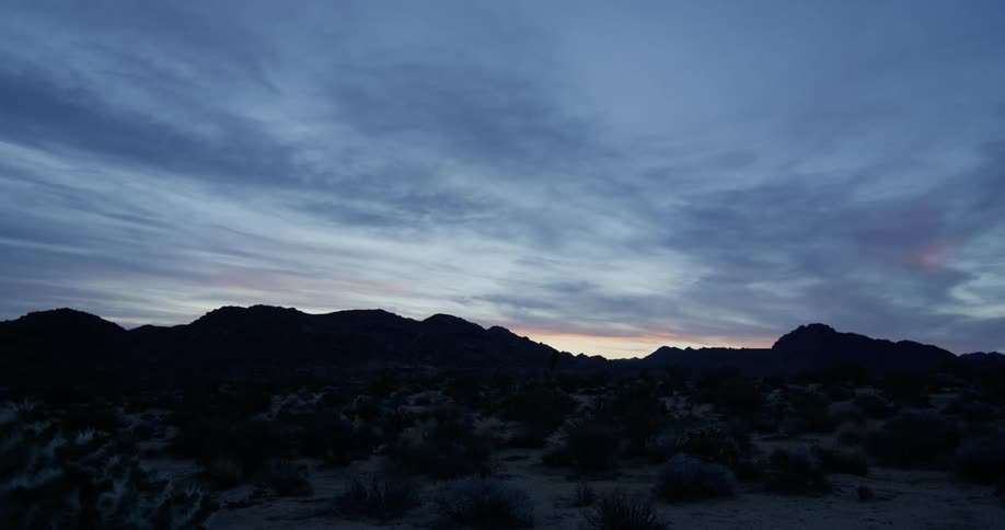 The sun is nearly set behind the mountain