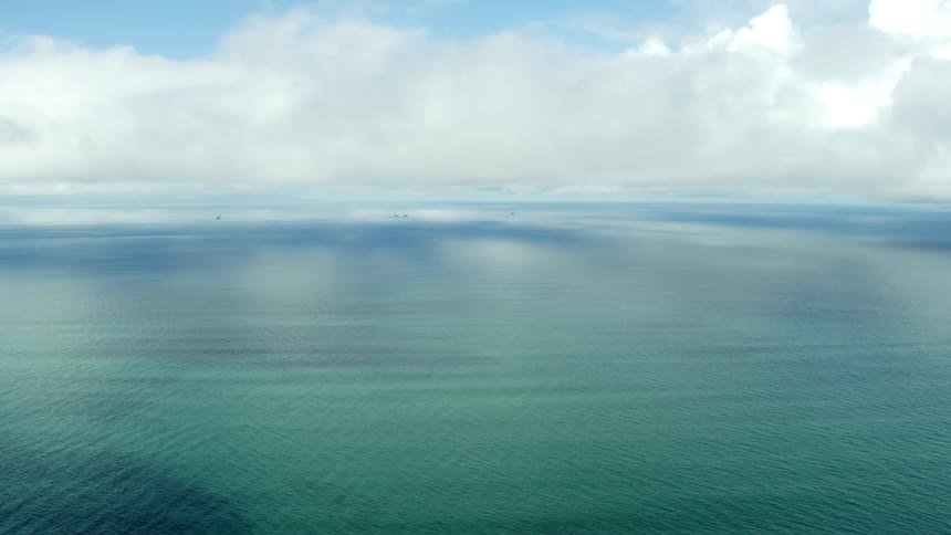 The vast ocean under white clouds on a sunny day