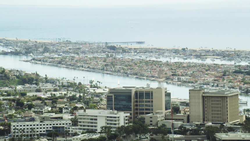 A city near the coast with rivers buildings and trees with the ocean in the background