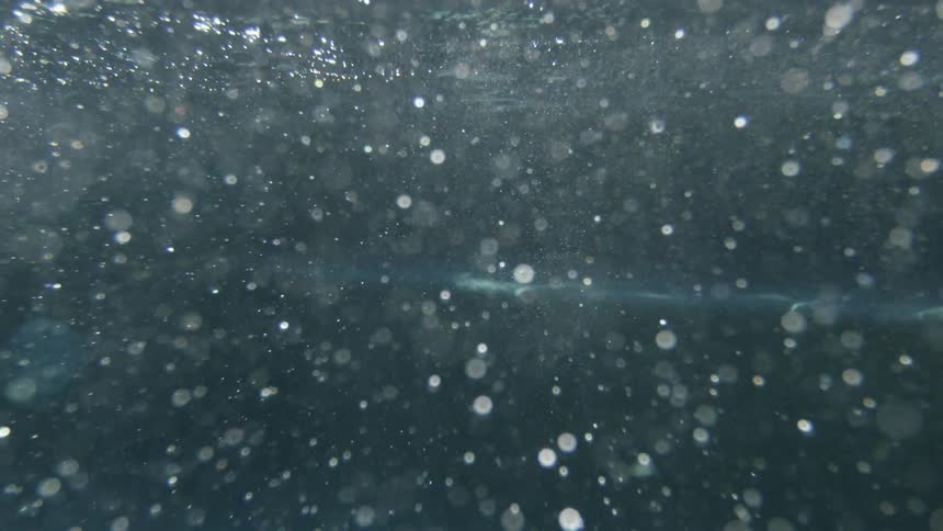 The sun shining down on bubbles underwater