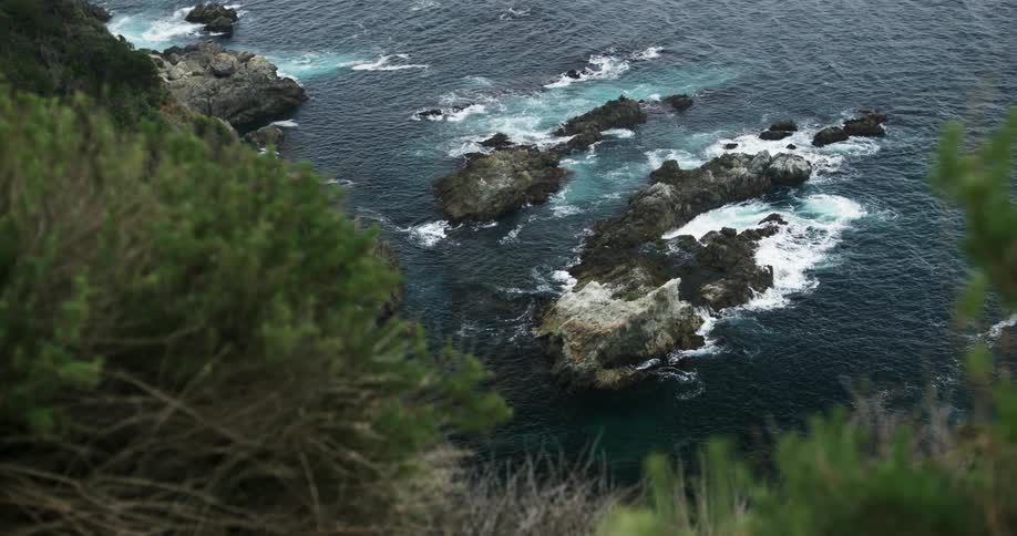 Waves crash on the rocks below the cliffs along a coast