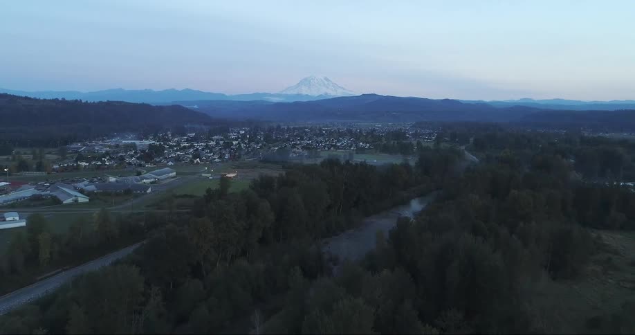 Small town in valley in front of mountain range and tall peak