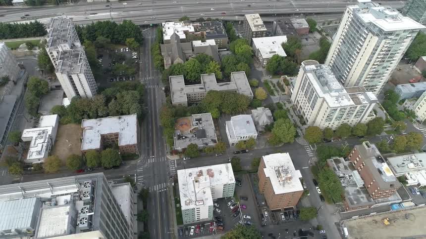 High rise buildings and apartment buildings flank a busy highway on both sides