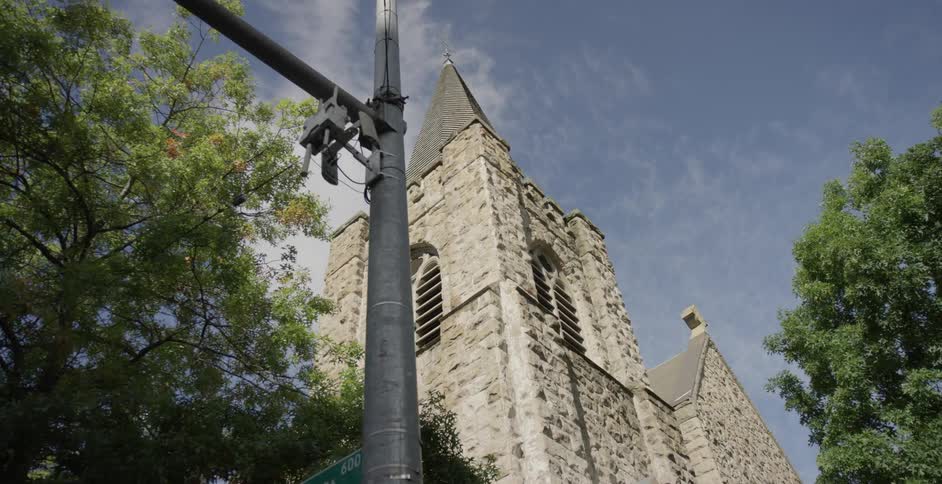 A steeple on the corner of a cathedral in a city during the day