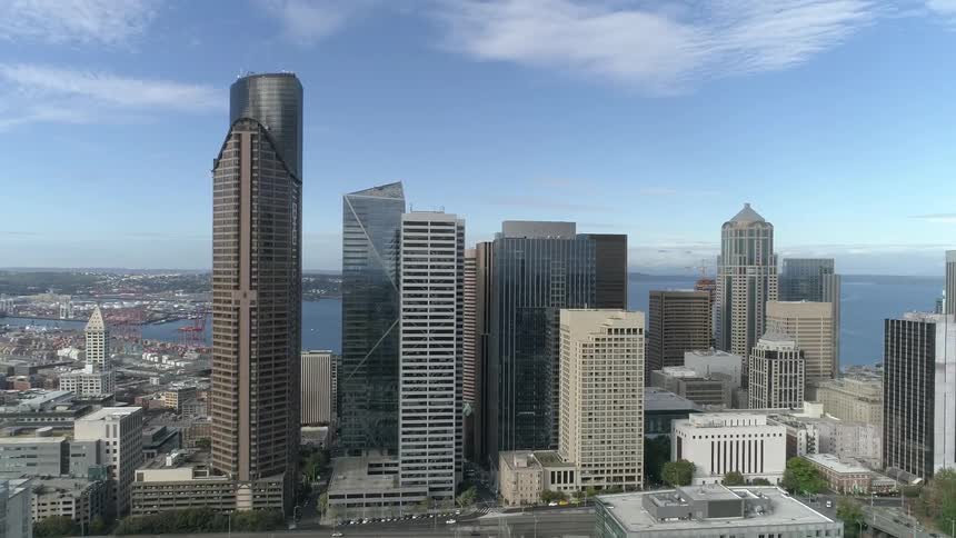 City downtown borders ocean front under azure sky